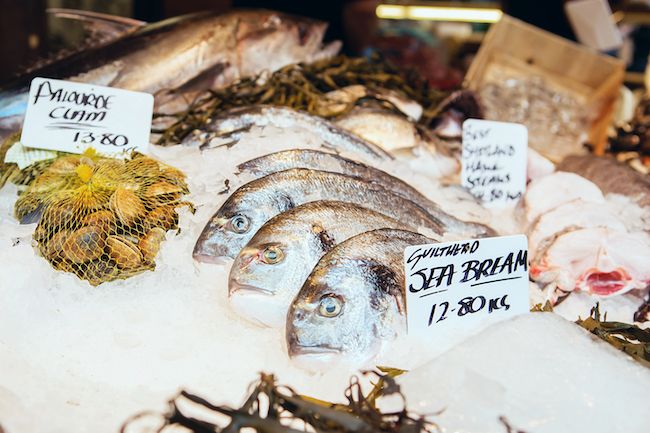 freshly caught sea bream fishes and other seafood on display at borough market in london